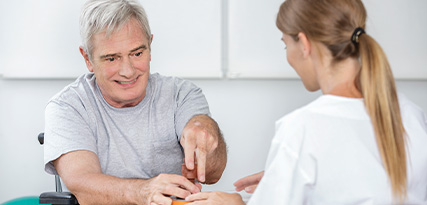 smiling elderly man interacting with healthcare professional during therapy session promoting 9 steps to recovery